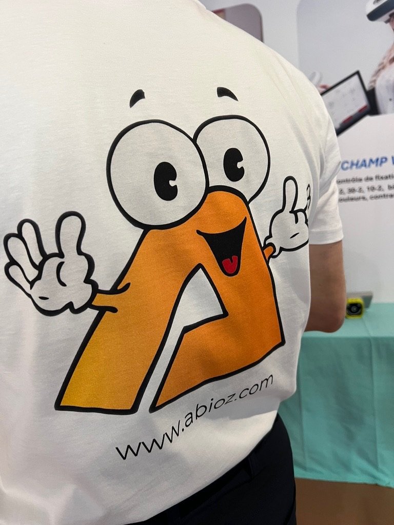 La mascotte d'Abioz Technologies, un A souriant, sur le t-shirt de l'équipe lors d'un congrès